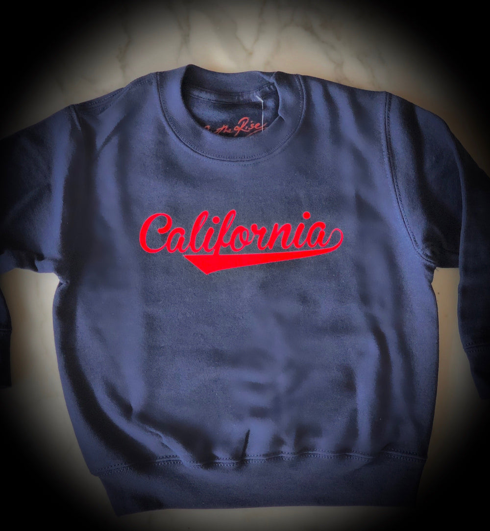 On The Rise CALIFORNIA Pullover Sweatshirt. blue sweatshirt with red text stating California in cursive text