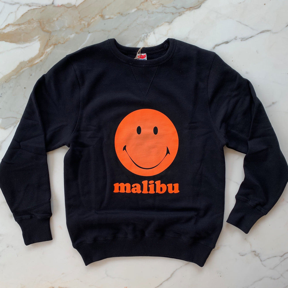 TSPTR Happy Pills Sweatshirt. Black sweater with an orange happy face in the middle and the word Malibu underneath it. 
