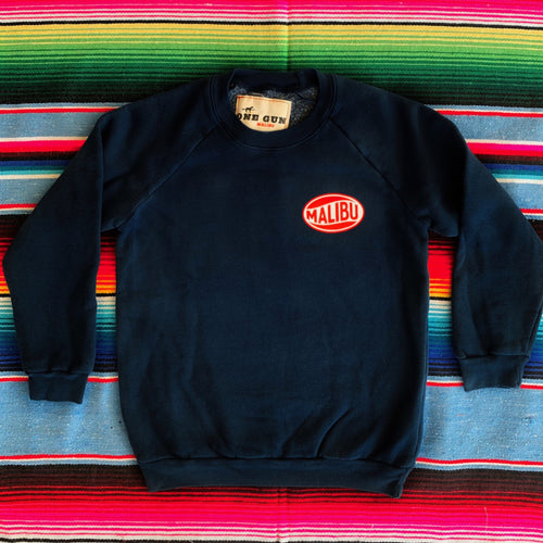 One Gun Vintage Malibu Kids Pullover. Navy sweater with Malibu printed on the left side. 