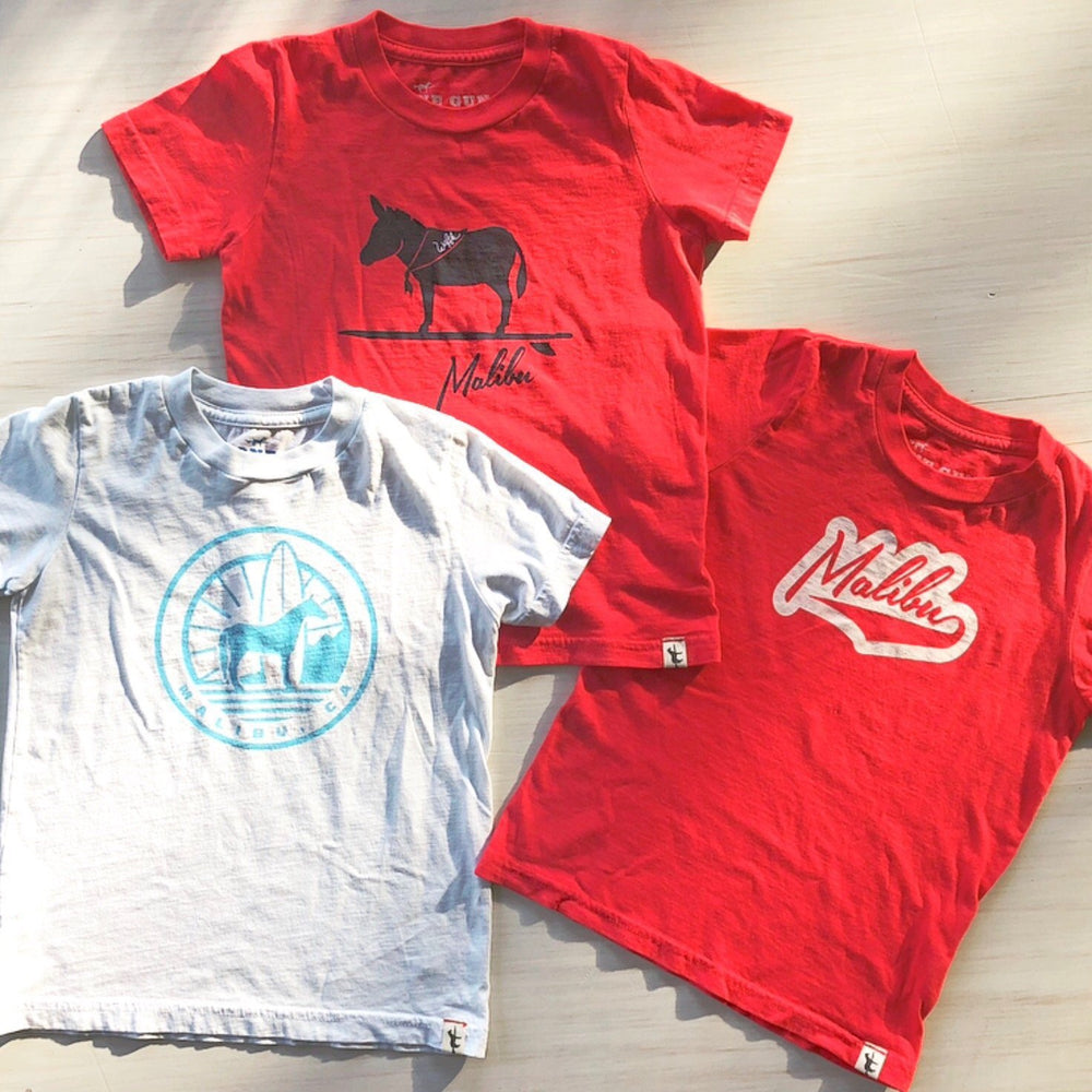 One Gun Sunrise Kids T-Shirt Horse. Red and white shirts with malibu designs on them. 