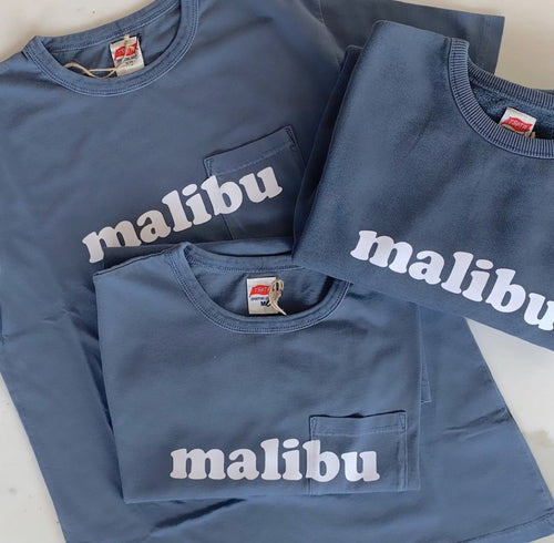TSPTR Pocket Faded Navy Malibu T-Shirt. Blue shirt with a pocket on the left side. The word Malibu printed across the front in white text. 