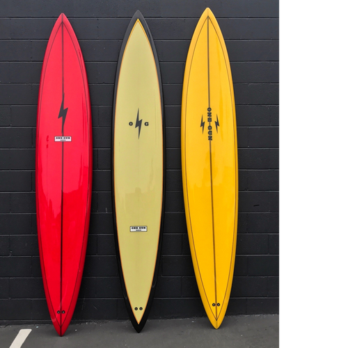 3 surfboards lined up. There's a red one on the left with a lightning bolt on the top center. The middle is a yellow board with black trim around the boarder. The right one is yellow with two lightning bolts and the logo One Gun in the middle. 