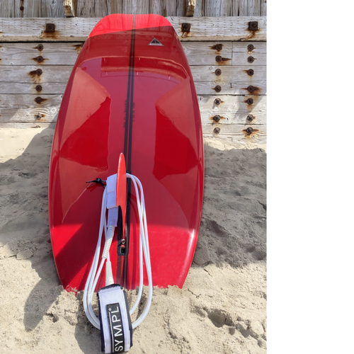 Harbour Surfboard. Red surfboard with a black stripe down the middle.  The fnin is red and the strap is white. 