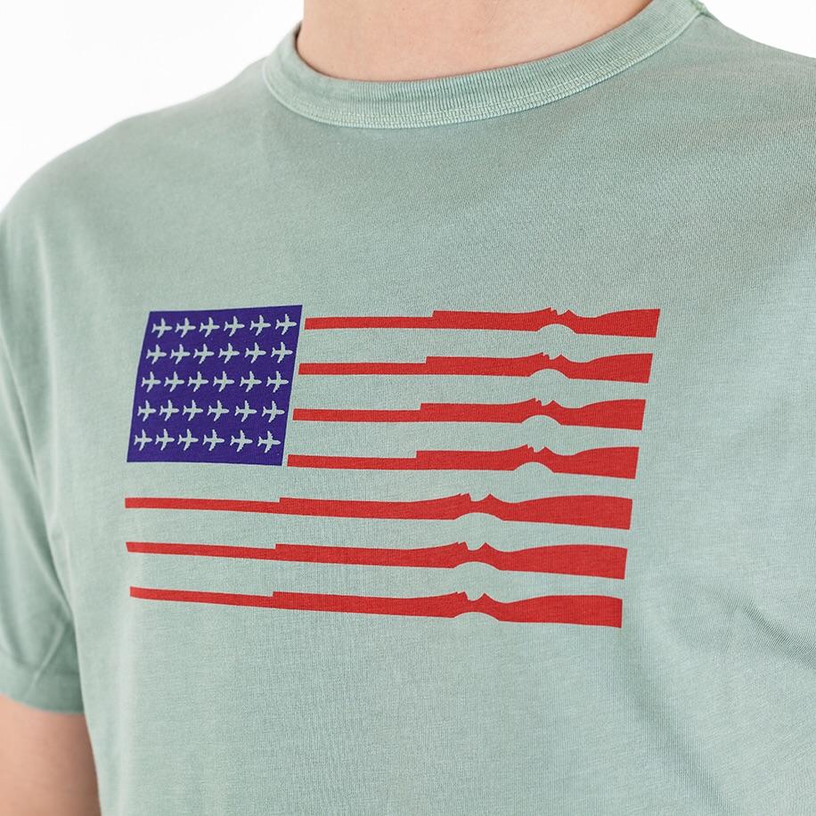 TSPTR Merica T-Shirt. A green shirt. A flag design where the stars are replaced by airplanes, and the stripes are guns. 