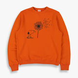 TSPTR My Reality Pullover. Orange sweater with a design of Snoopy blowing a dandelion flower. 
