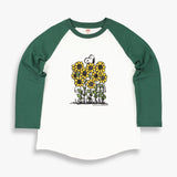 TSPTR Sunflowers Raglan T-Shirt. White shirt with green sleeves. It has a design of Snoopy in a field of tall sunflowers.  Edit alt text